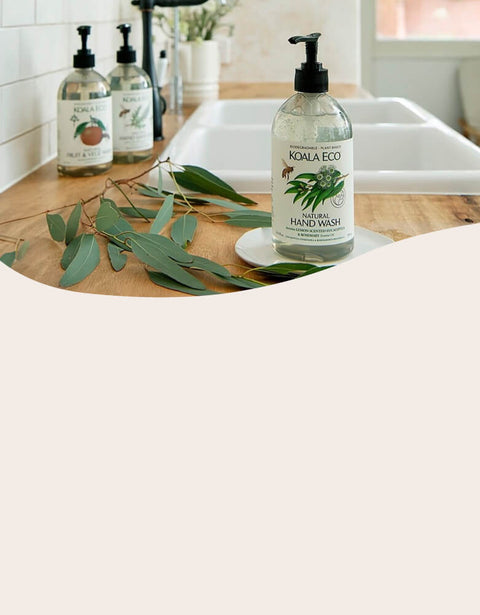 Hand wash bottle on a kitchen counter with eucalyptus leaves.