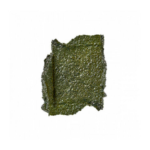 Swatch of brightening facial scrub - green, grainy texture.