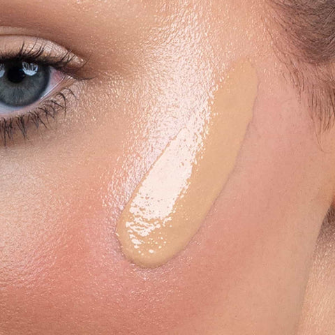 Close-up of bronzing drops applied to skin.