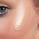 Close-up of bronzing drops applied to skin.