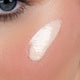 Close-up of a person's eye with glow drops applied to the cheekbone.