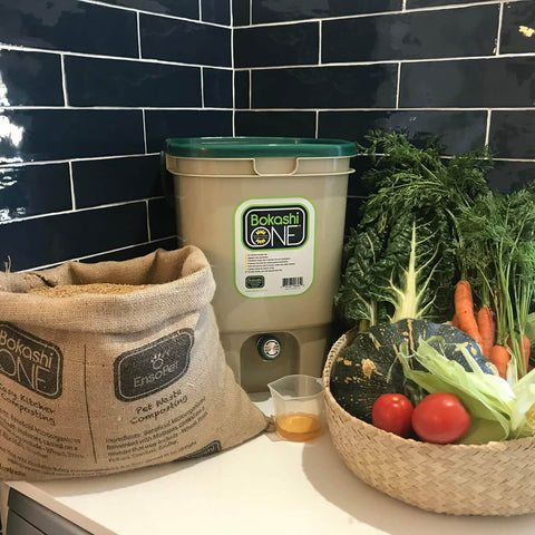 Bokashi One composting system with a bag and vegetables on a counter.