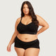 A plus-size model wearing a black two-piece bra and panty set with the brand name 'boody' visible on the waistbands, set against a solid light grey background.