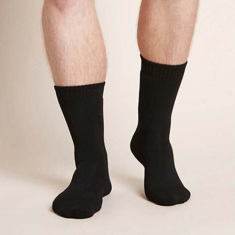 Black crew boot socks worn by a man on a beige background