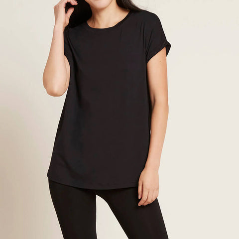A model wearing a black, lightweight lounge top made of organic bamboo, featuring a softly curved neckline, back seam detail and a subtle curved high-to-low-hem, showing the front.