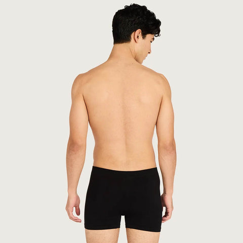 A man shown from the back wearing black boxer briefs, photographed against a plain light gray studio background.
