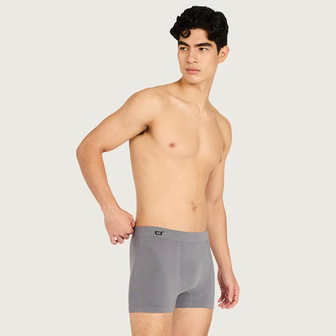 A shirtless male model wearing gray boxer briefs, standing against a light gray studio background.