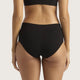 Rear view of a model wearing black high-waisted briefs and a matching black sports bra against a light gray studio background.