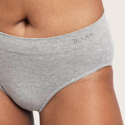 Close-up of a model wearing light heather gray high-waisted briefs with the brand name 'BOODY' printed on the waistband, against a plain light background.