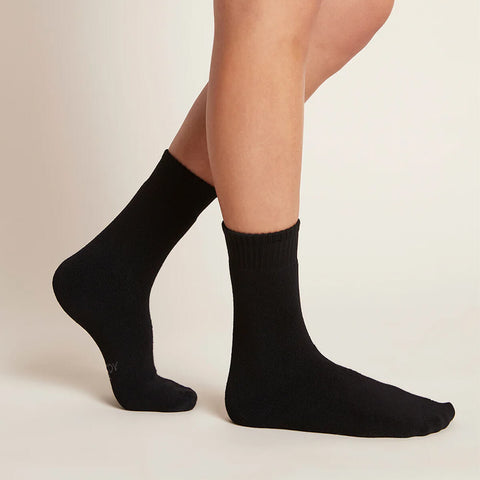 A pair of black, women's crew boot socks modelled on feet.
