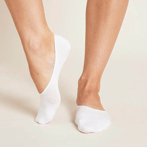 White no-show socks worn by a model standing against a neutral background