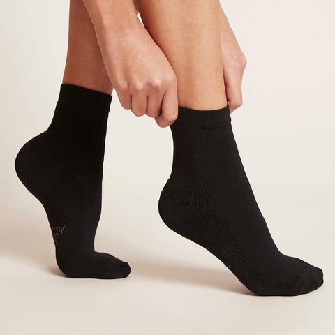 A pair of black, women's quarter crew socks modelled on feet.