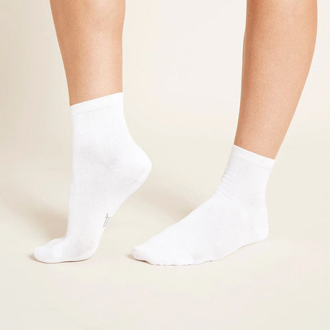 A pair of white, women's quarter crew socks modelled on feet.