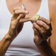 Person applying a small container of healing lip balm to their finger