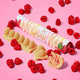 Obar vegan white chocolate raspberry ripple bar with raspberries on a pink background.