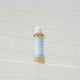Bottle of Dr. Bronner's Pure-Castile Soap on a white tiled wall