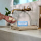 Bar of soap with a blue label on a towel next to a sink