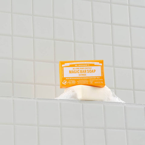 Bar of soap with a yellow label on a tiled bathroom shelf.