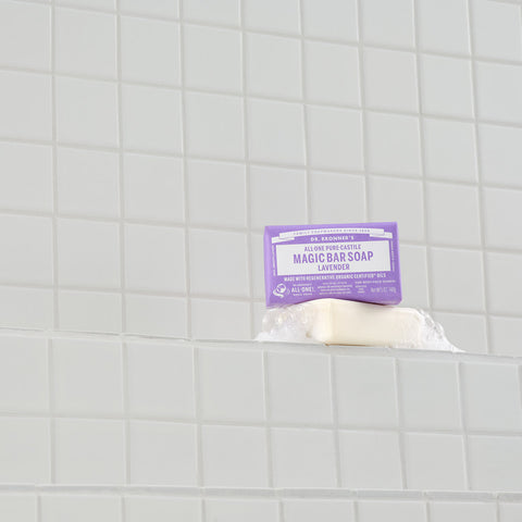 Bar of soap with a purple label on a tiled bathroom wall