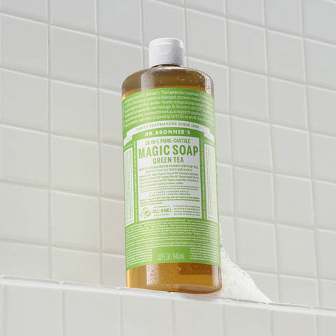 Bottle of Dr. Bronner's Magic Soap Green Tea on a tiled shower wall.