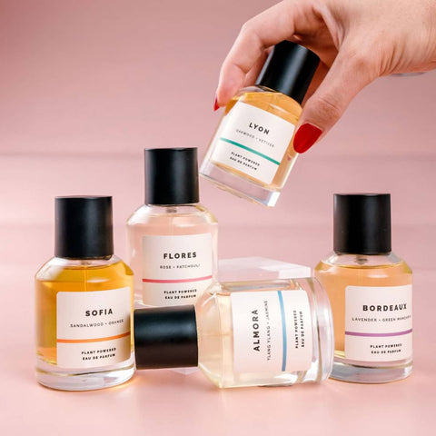 Collection of ECO. Modern Essentials natural perfume bottles with visible labels on a pink background.