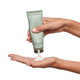 Hand holding a tube of Endota Organics avocado & mint foot cream being squeezed out onto palm.