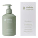 A hand holding a pump bottle of Endota Gentle Bath & Body Wash against a solid white background.