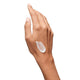 Hand with a small amount of cream on the palm against a white background
