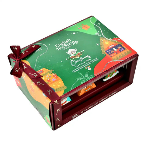 English Tea Shop Christmas Tea Collection gift box, featuring a festive green and red illustrated package with a dark red ribbon bow.