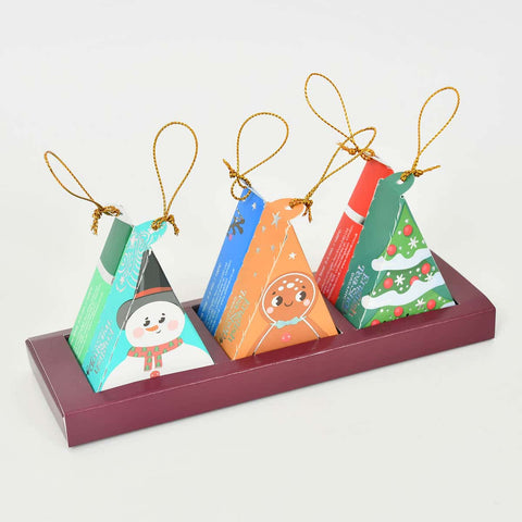 Set of 6 colourful Christmas-themed paper ornaments with tea inside.