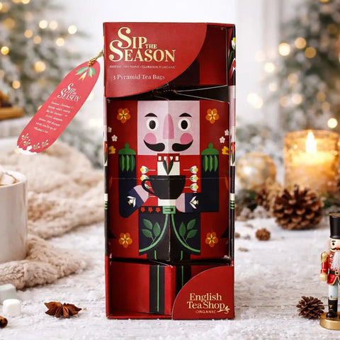 A boxed holiday tea bar set from Sip the Season, featuring a red nutcracker-themed package with illustrated figures and a hanging red tag.