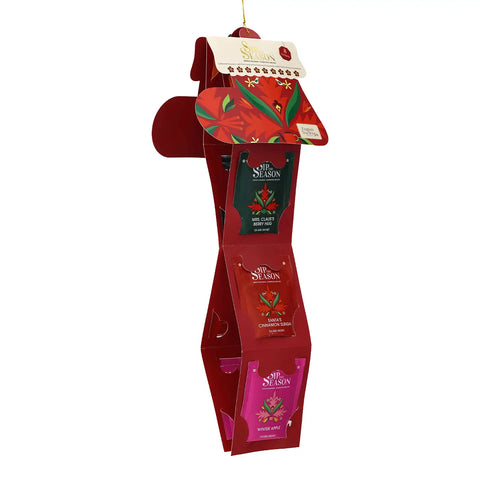 A hanging red holiday display stand with multiple tea packets attached, photographed on a plain white background.