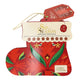 A Christmas stocking-shaped tea gift set from English Tea Shop, featuring red and green festive patterns, a hanging gold string, and a cream-colored paper.
