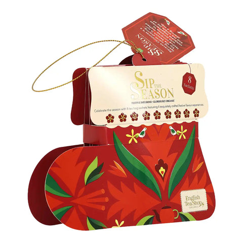 A festive red and green 'Sip of the Season' tea box set by English Tea Shop, featuring a hanging gold string and a cream-colored paper insert card.