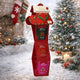 A red Christmas gift box display stand filled with seasonal packaged items, photographed in a snowy holiday scene.