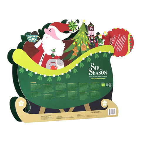 A Christmas-themed cardboard standee or sign featuring Santa Claus in a sleigh with a decorated tree, gifts, and text reading 'Sip the Season'.
