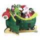A festive Santa Claus advent calendar shaped like a sleigh with green panels, numbered doors, a Christmas tree, nutcracker, and illustrated Santa and reindeer.