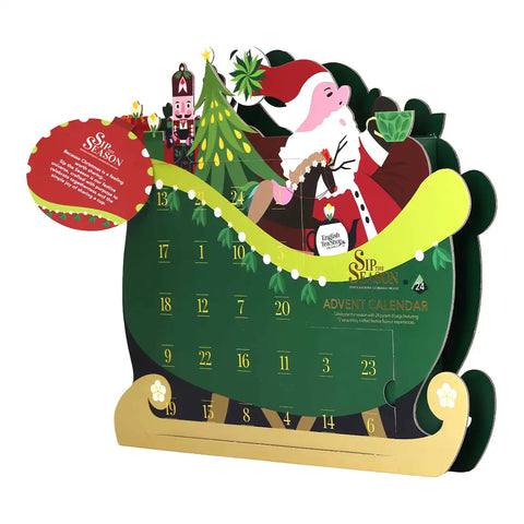 A Christmas advent calendar shaped like a green sleigh with gold wheels and base.