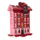 A pink and red cardboard advent calendar shaped like a multi-story house with illustrated windows.