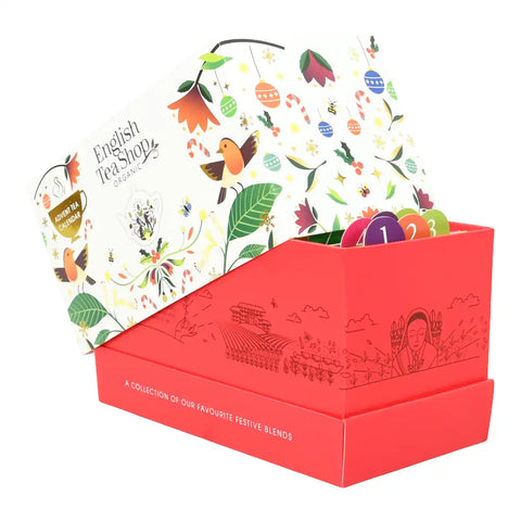 Advent tea box, featuring a bright red outer box with delicate line-art illustrations, a white inner box decorated with colorful festive illustrations.