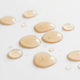 Light orange-coloured droplets on a white surface.