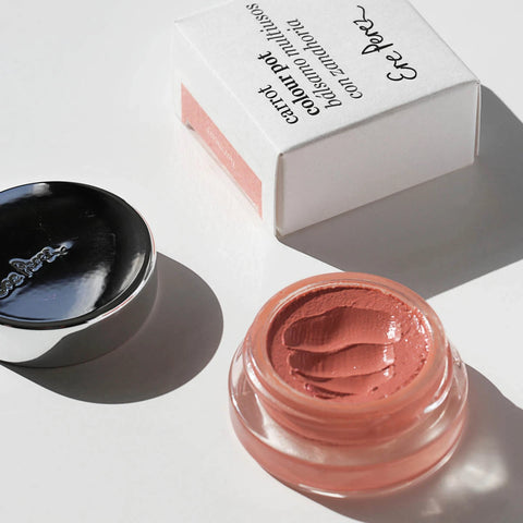Pink carrot colour pot in the shade harmony. Aluminium lid sitting to the side with white cardboard packaging. 