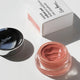 Pink carrot colour pot in the shade harmony. Aluminium lid sitting to the side with white cardboard packaging. 