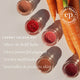 Carrot-coloured cosmetic pots with a 'Clean Beauty Benchmark' logo and text about product features.