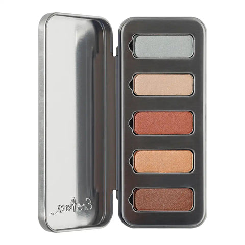 Eyeshadow palette with five rectangular pans in silver, champagne, bronze, peach, and brown shades, shown with its metallic silver tin lid open on a white background.