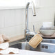 Ever Eco Loofah Dish Sponge styled in a kitchen sink hanging from its loop on the tap.