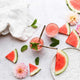 Ever Eco stainless steel drinking straws pictured in a glass of juice with watermelon, mint & flowers as styling elements.