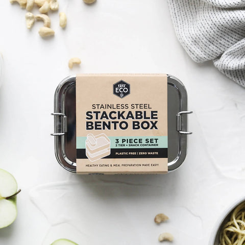 Stainless Steel Stackable Bento Box on a white surface with fruit and nuts scattered.