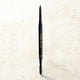 Black eyebrow pencil with 'Eve of Horus' branding on a light beige background