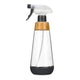 A Full Circle clear glass spray bottle with a black trigger sprayer, a light brown bamboo wood collar, and a dark grey silicone base, shown on a plain white background. Eco-friendly refillable spray bottle. 